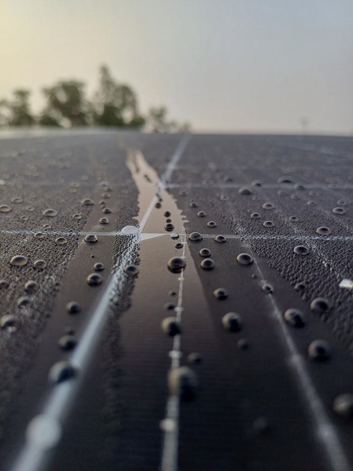 Dew droplets on solar panel in São João do Piauí, Portugal, reflecting morning light.